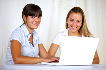 Smiling young businesswomen using laptop together