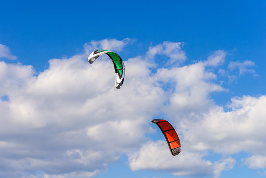 Two surf kites against a blue sky