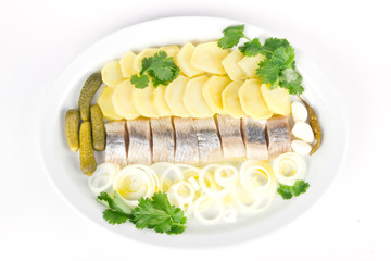 Portion of herring fish fillets with potato and onion