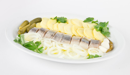 Portion of herring fish fillets with potato and onion