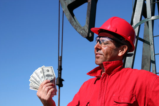 Oil Worker With Dirty Face Holding US Dollar Bills