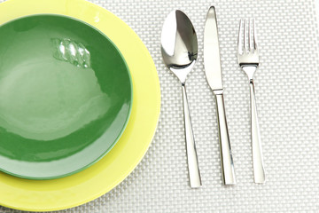 Green empty plates with fork, spoon and knife