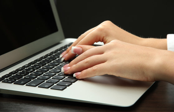 female hands writing on laptot, close up