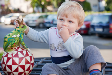 Little toddler boy with handmade toy frog