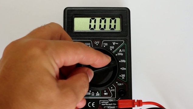 Man measures digital multimeter