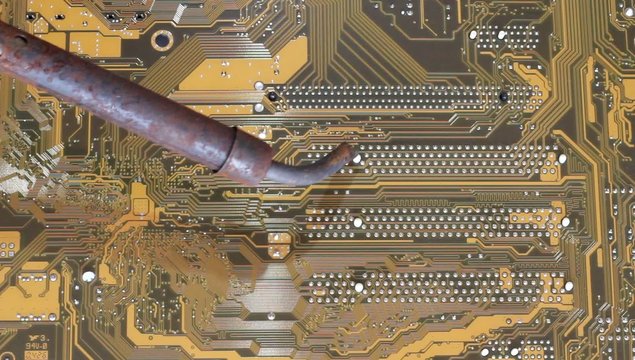 Man soldering iron soldering PC's motherboard