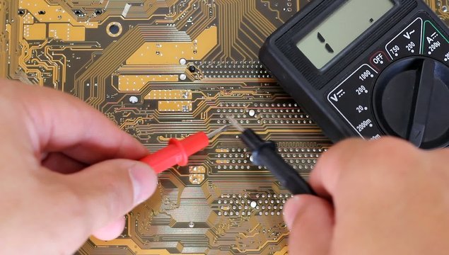 Man measures multimer motherboard.