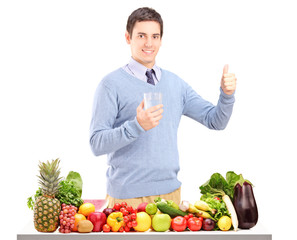 Man holding a glass and standing next to a pile of food