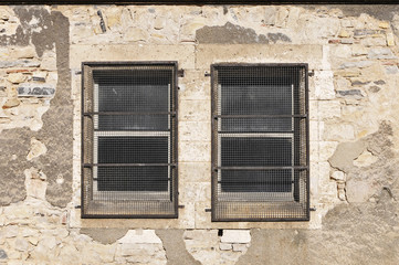 Fototapeta na wymiar two little windows with metallic protections