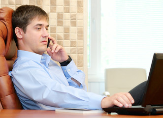 Naklejka premium Man in the office talking by phone