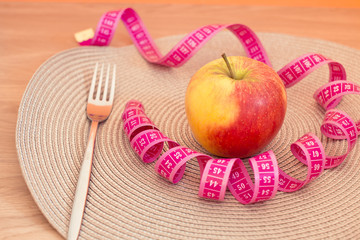 apple and fork with measuring tape