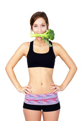 Healthy young woman eating broccoli