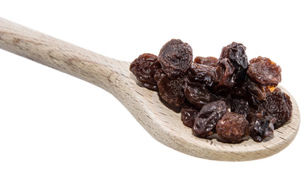 Raisins on a wooden spoon against white
