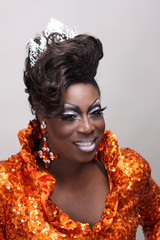 Drag queen wearing an orange gown with sequins.