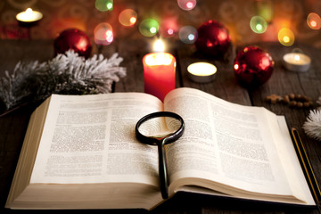 Christmas and bible with blurred candles light background