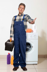 Portrait of an happy plumber against the washing machine © Andrey Burmakin