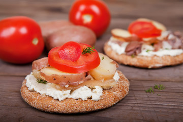 Two sandwiches with herring and tomatoes on the table