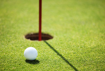 golf ball on lip of cup