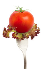 The fresh tomato on fork isolated at white background