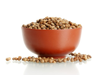 Heap coriander seeds in ceramical bowl isolated on white