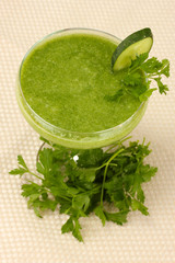 Green vegetable juice in coctail glass on light background