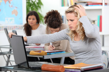 Fototapeta na wymiar female student using laptop in class at college