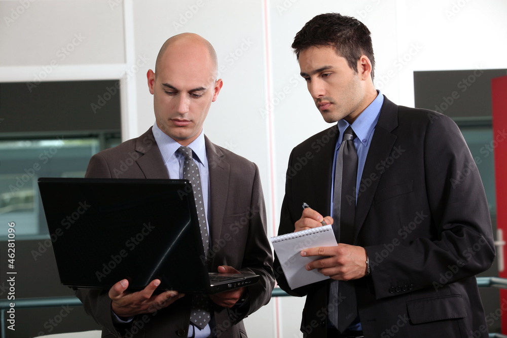 Wall mural duo of young businessmen with laptop