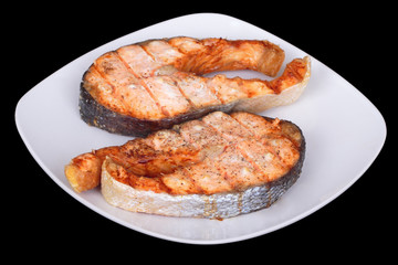 Two Salmon steak with on plate. Isolated on black