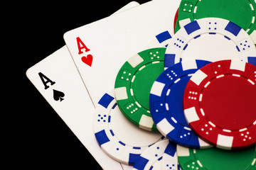 Pair of aces and poker chips isolated on black background