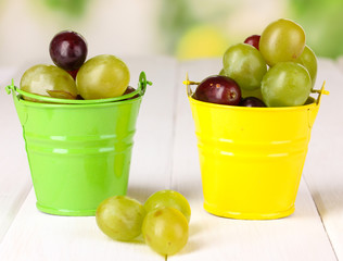 Ripe green and pink grapes in colorful pails