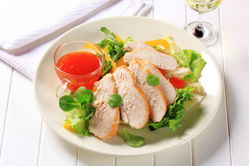 Sliced chicken breast with salad and sweet chilli sauce