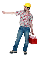 Construction worker carrying a toolbox, studio shot