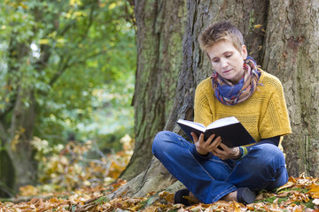 Fototapeta premium Woman reading book in the park
