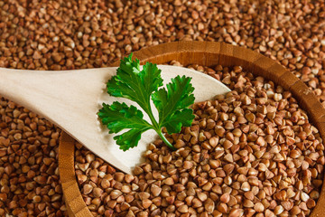 Buckwheat is on the plate with  wooden spoon
