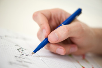 Naklejka premium human hand with pen over financial diagram