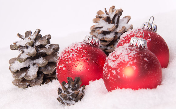 Weihnachtskugeln rot Schnee Tannenzapfen