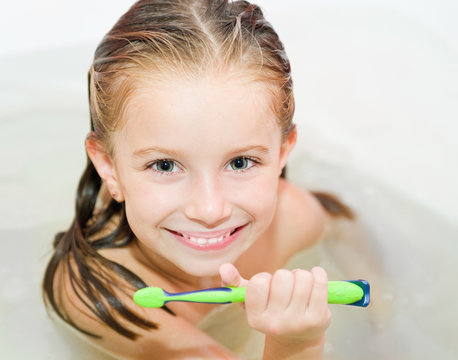 girl brushing teeth in bath