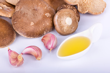 setas de cardo con ajo y aceite sobre fondo blanco
