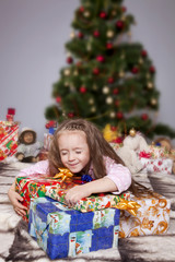 Fototapeta na wymiar The girl with a gift under the Christmas tree