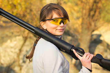 Young beautiful girl with a shotgun
