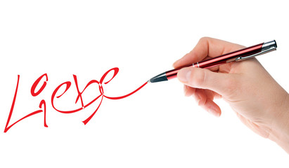 Hand mit Stift schreibt das Wort Liebe