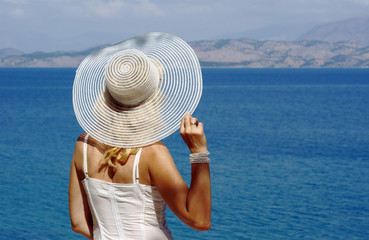 dziewczyna w białej sukience i kapelu nad morzem