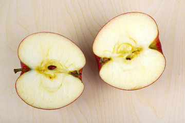 Halved apple in wooden table