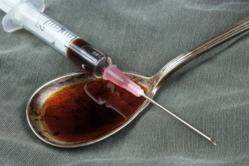 Drug syringe and cooked heroin on spoon - 46319862