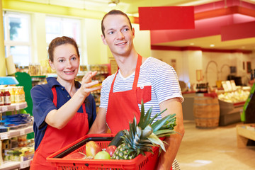 Kauffrau hilft Azubi im Supermarkt