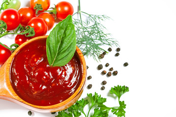 Red tomato sauce in a spoon and ingredients, isolated in white