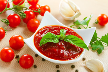 Red tomato sauce in a pan and ingredients