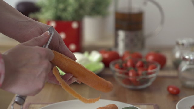 Female hands peeling carrot