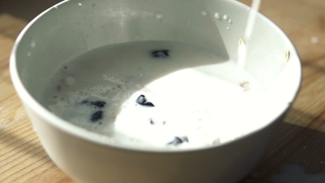 Pouring milk into bowl with muesli
