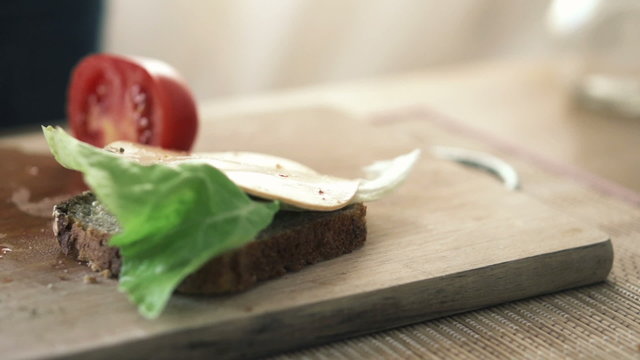 Caprese cheese, lettuce and tomato falling on slice of bread